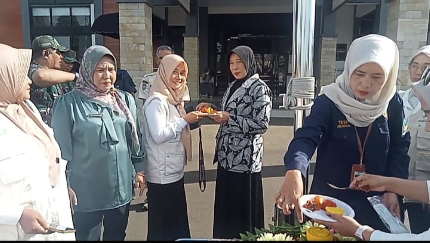 Ketua IPSM, Rodiah menyampaikan potongan tumpeng kepada Ketua TP PKK Kecamatan Dramaga, Lilis R Sumaryo